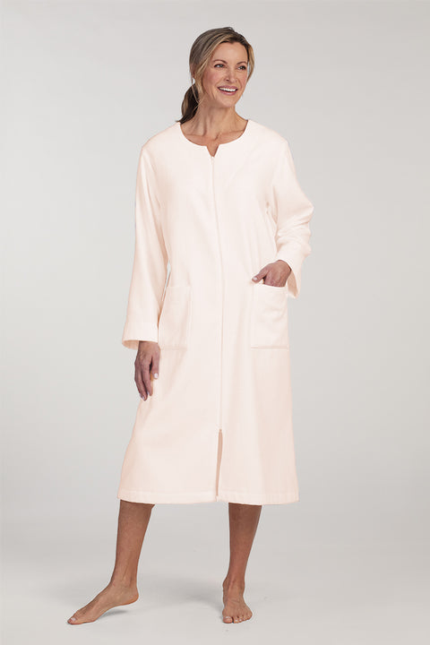 Terry long zip robe in cream, front view, modeled on woman with pockets and three-quarter sleeves visible.