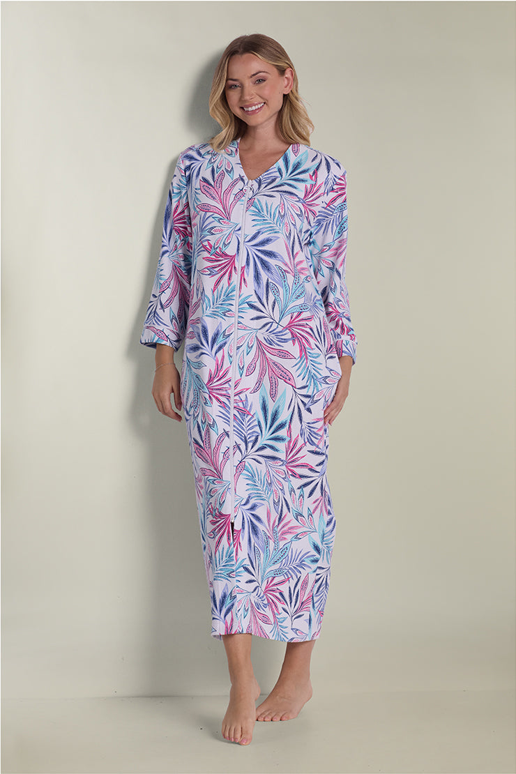 Woman wearing a long interlock knit robe with pink and blue floral leaf pattern, three-quarter sleeves, full-length view.