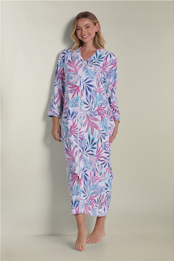 Woman wearing a long interlock knit robe with pink and blue floral leaf pattern, three-quarter sleeves, full-length view.